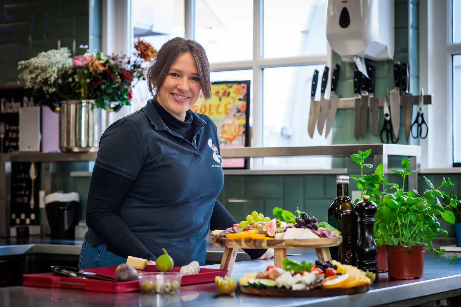 Elise maakt grazing planken op aan de werkbank in de keuken
