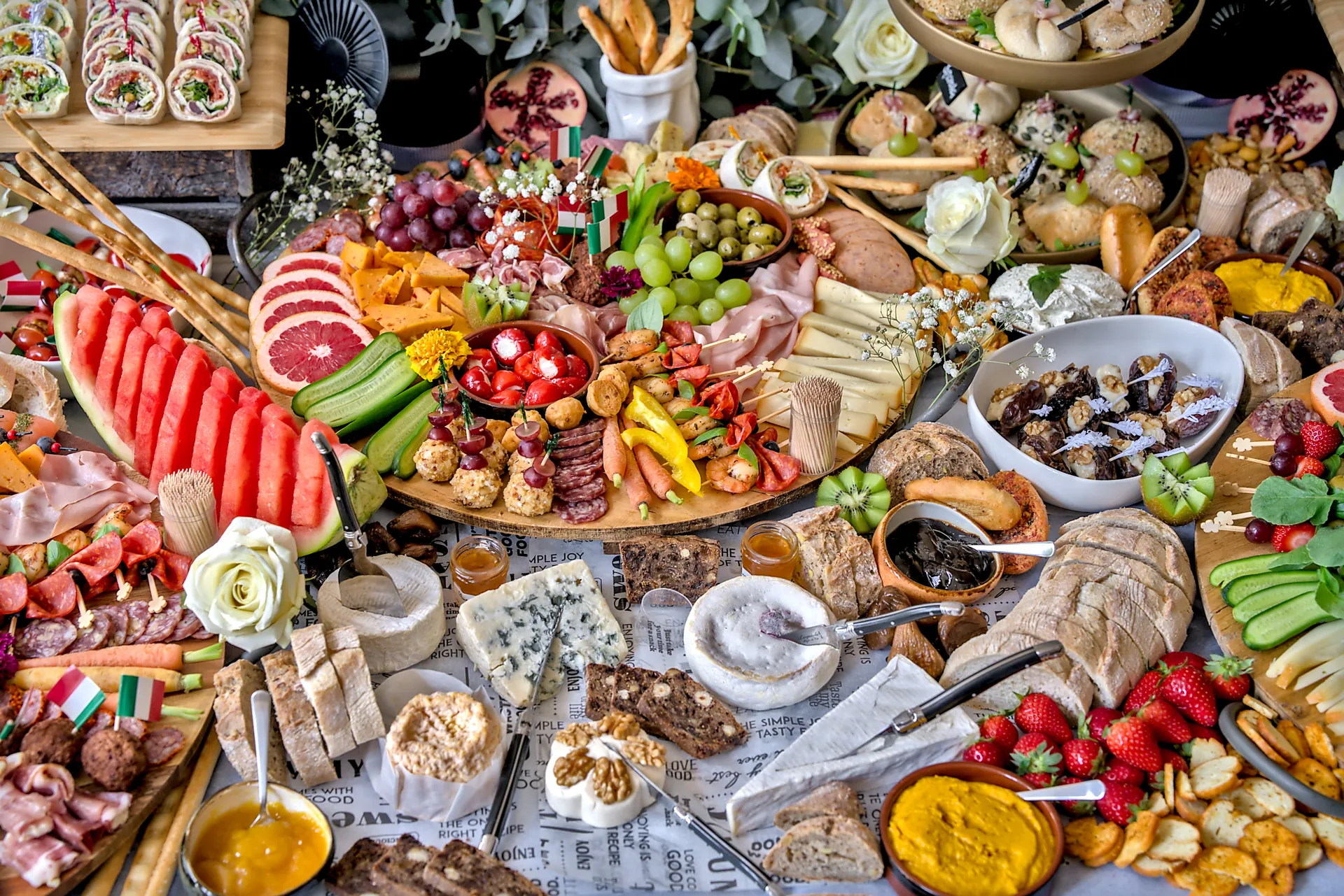 Grazing table met Italiaanse vleeswaren, kazen, wraps, watermeloen en dips, van bovenaf