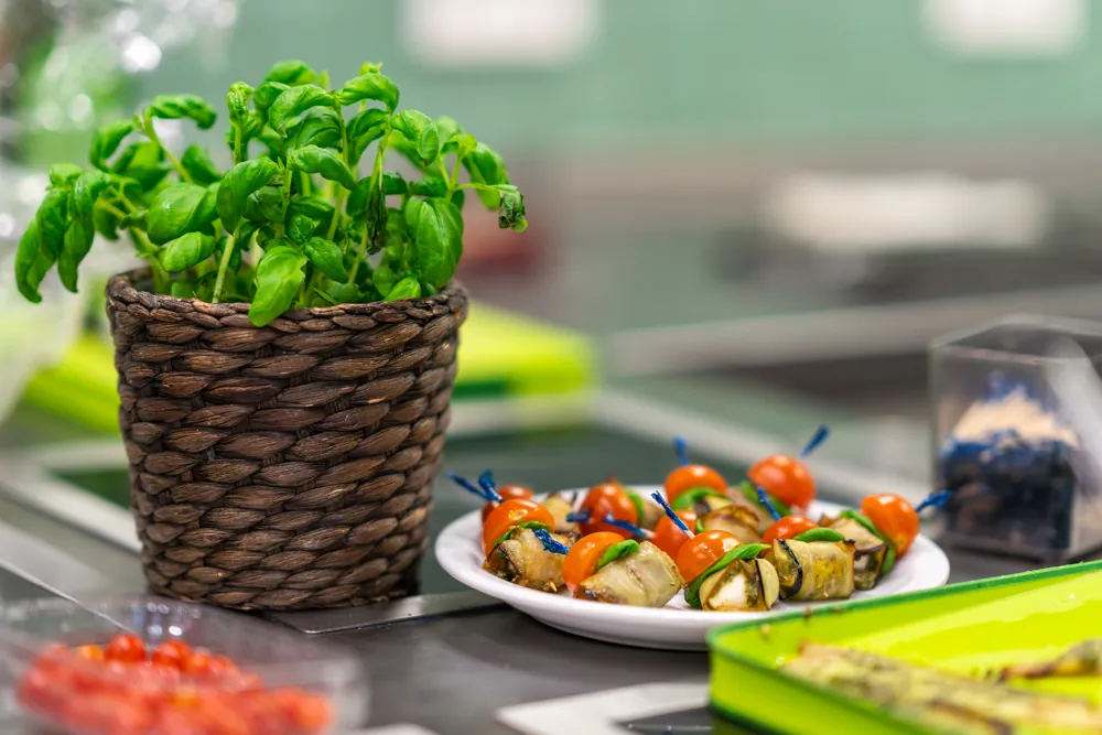Rustige tafel in de keuken met basilicum en een schaal met spiesjes